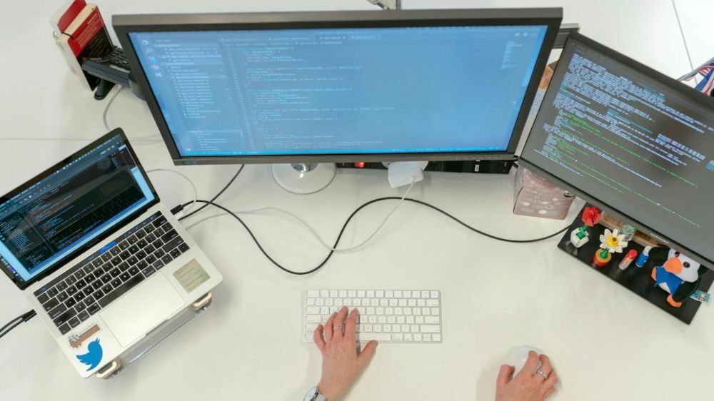 person coding at computer screens